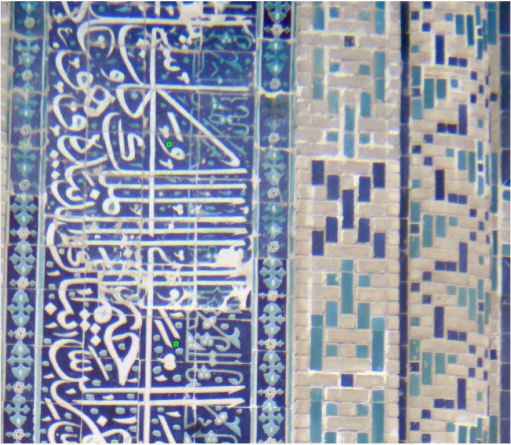 Detail of glazed tile decoration with blue calligraphy and two measured points